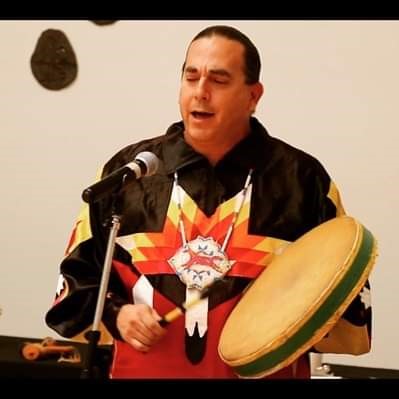 photo of man in native people attire with drum